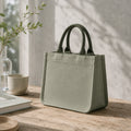 Sage green mini canvas tote with deep forest green handles, flat bottom and soft structured shape.