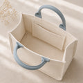 Open interior of ivory mini canvas tote with mist blue handles and inner pocket.