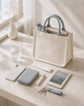 Ivory mini canvas tote with mist blue handles holding everyday essentials.