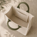 Open interior of oatmeal mini canvas tote with muted olive handles and inner pocket.