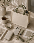 Oatmeal mini canvas tote with muted olive handles holding everyday essentials in a natural light setting.