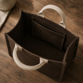 Open interior of raw umber mini canvas tote with oatmeal handles and inner pocket.